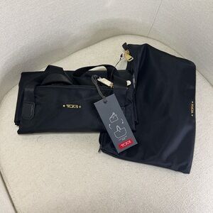 Tumi Black Nylon Travel duffel bag with carrying pouch  with Gold Hardware